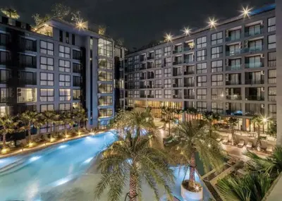 a large swimming pool with palm trees in front of buildings at Great 1BDR Kamala 500m to beach in Kamala Beach