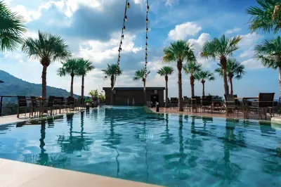 a large swimming pool with palm trees in the background at Great 1BDR Kamala 500m to beach in Kamala Beach