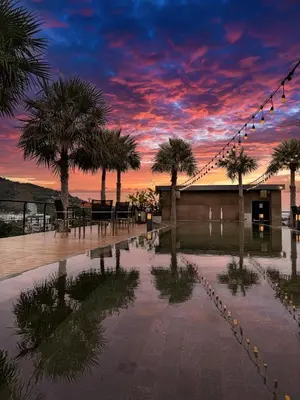 a sunset with palm trees and lights in a courtyard at Great 1BDR Kamala 500m to beach in Kamala Beach