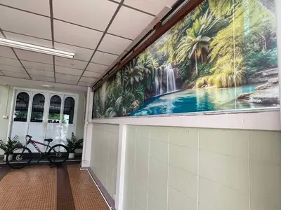 a large painting of a waterfall on the wall in a hallway at 9 Home Phuket in Ban Rangeng