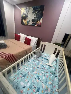 a baby crib in a bedroom with a bed at 9 Home Phuket in Ban Rangeng