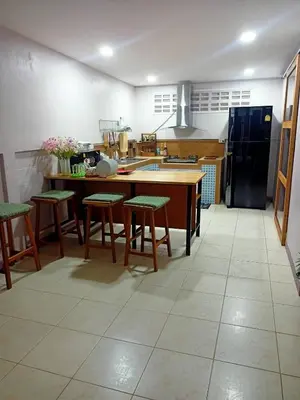 a kitchen with a table and some chairs in it at 9 Home Phuket in Ban Rangeng