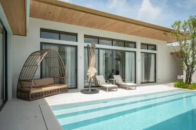 a villa with a swimming pool and a house at Mouana Breeze Maikhao 3-bedroom Pool Villa 9917 in Mai Khao Beach