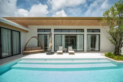 a villa with a swimming pool and a house at Mouana Breeze Maikhao 3-bedroom Pool Villa 9917 in Mai Khao Beach