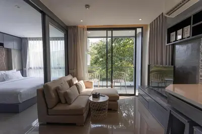 a bedroom with a bed and a couch and a chair at C182 Kamala 1BR Stay Near Beach & Attractions in Kamala Beach