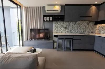 a living room with a couch and a kitchen at C182 Kamala 1BR Stay Near Beach & Attractions in Kamala Beach