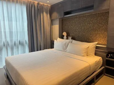 a hotel room with a bed with white sheets and a window at C182 Kamala 1BR Stay Near Beach & Attractions in Kamala Beach