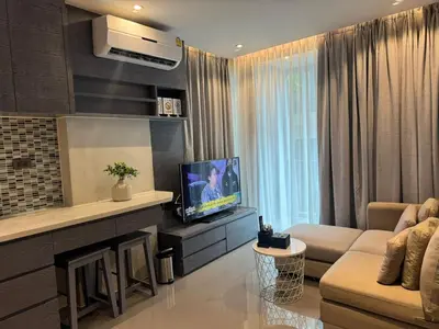 a living room with a couch and a television at C182 Kamala 1BR Stay Near Beach & Attractions in Kamala Beach