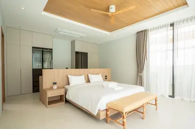 a bedroom with a large bed and a wooden ceiling at Mouana Breeze Mai Khao 4-bedroom Pool Villa 9925 in Mai Khao Beach