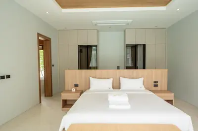 a bedroom with a large white bed in a room at Mouana Breeze Mai Khao 4-bedroom Pool Villa 9925 in Mai Khao Beach