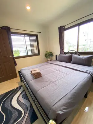 a large bed in a room with a large window at Fran Sim Da Guest House in Bang Tao Beach