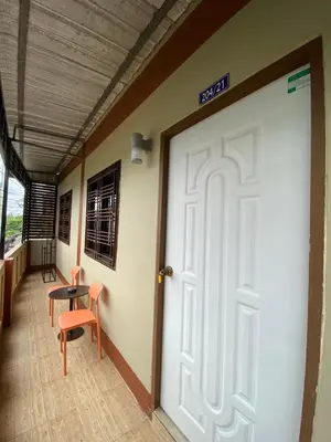 a door in a hallway with a table and chairs at Fran Sim Da Guest House in Bang Tao Beach