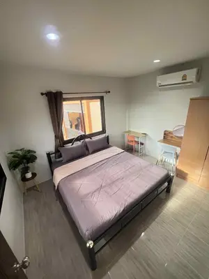 a bedroom with a large bed and a window at Fran Sim Da Guest House in Bang Tao Beach
