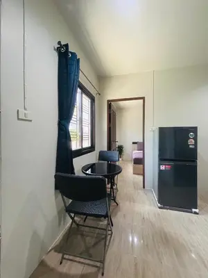 a room with chairs and a table and a refrigerator at Fran Sim Da Guest House in Bang Tao Beach