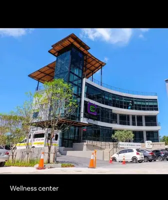 a building with a tower in front of a parking lot at City Gate Apartments Kamala Beach Phuket Thailand - LMY in Kamala Beach