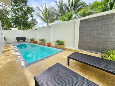 a swimming pool in a backyard with a bench next to it at Kamala Green View Pool Villa in Kamala Beach