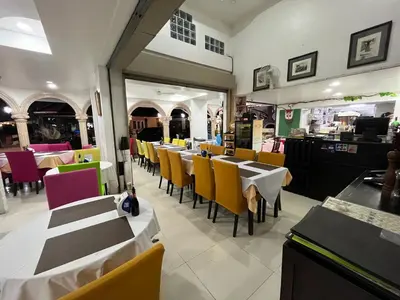 a dining room with tables and chairs in a restaurant at Da Mario Hotel & Restaurant in Karon Beach