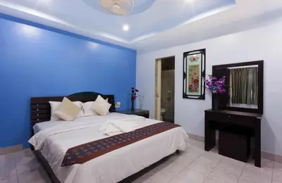 a bedroom with a large bed and a blue wall at Da Mario Hotel & Restaurant in Karon Beach