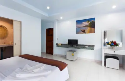 a white bedroom with a bed and a desk at Da Mario Hotel & Restaurant in Karon Beach