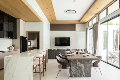 a kitchen and dining room with a table and chairs at Mouana Breeze Mai Khao 4-bedroom Pool Villa 9922 in Mai Khao Beach