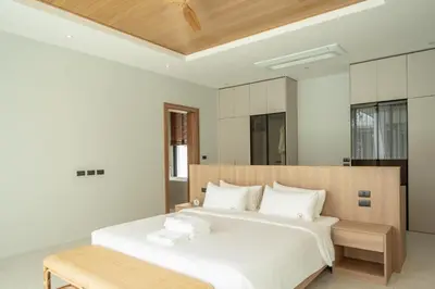 a bedroom with a large white bed with white pillows at Mouana Breeze Mai Khao 4-bedroom Pool Villa 9922 in Mai Khao Beach