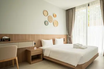 a bedroom with a bed and a desk and a window at Mouana Breeze Mai Khao 4-bedroom Pool Villa 9922 in Mai Khao Beach