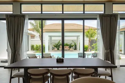 a large dining room with a table and chairs at Mouana Breeze Mai Khao 4-bedroom Pool Villa 9921 in Mai Khao Beach