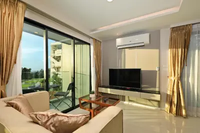 a living room with a tv and a large window at 1bdr Modern Apartment Cozy Seaview Stay in Surin Beach