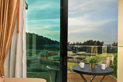 a room with a view of a balcony with a table at 1bdr Modern Apartment Cozy Seaview Stay in Surin Beach