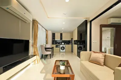 a living room with a couch and a tv and a table at 1bdr Modern Apartment Cozy Seaview Stay in Surin Beach