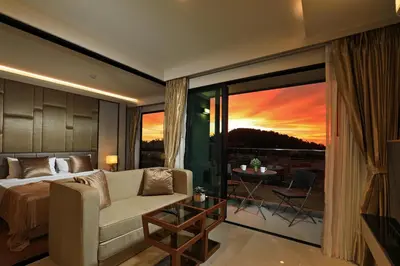 a bedroom with a bed and a couch and a large window at 1bdr Modern Apartment Cozy Seaview Stay in Surin Beach