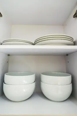 two white bowls on a shelf with an open book at Lux 2Bdr Cassia Laguna With Own Large Terrace in Laguna Phuket