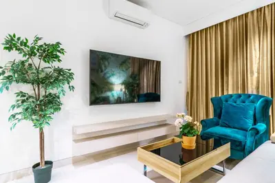 a living room with a blue chair and a tv at Lux 2Bdr Cassia Laguna With Own Large Terrace in Laguna Phuket