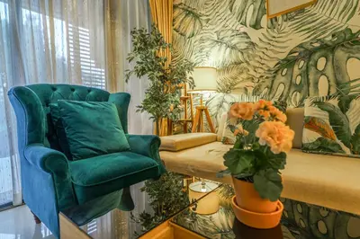 a living room with a green chair and a vase of flowers at Lux 2Bdr Cassia Laguna With Own Large Terrace in Laguna Phuket