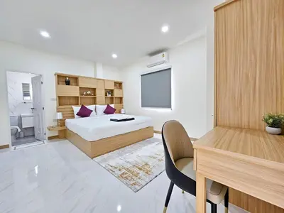 a bedroom with a bed and a desk and a television at The Green View Pool Villa in Kamala Beach