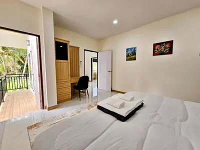 a bedroom with a large white bed in a room at The Green View Pool Villa in Kamala Beach