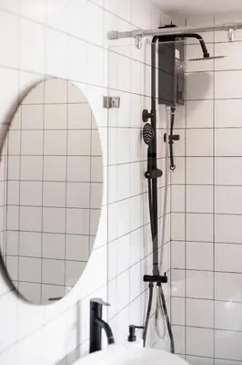 a shower head in a bathroom with a mirror at Kamala Modern 2 bedroom Apartment in Kamala Beach