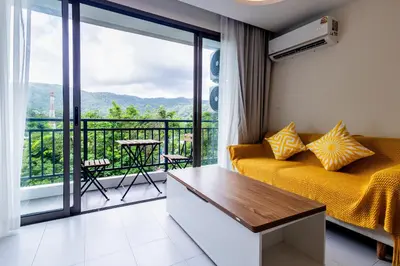 a room with a bed and a balcony with a view at Kamala Modern 2 bedroom Apartment in Kamala Beach