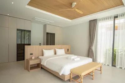 a bedroom with a large white bed and a ceiling at Mouana Breeze Mai Khao 4-bedroom Pool Villa 9920 in Mai Khao Beach