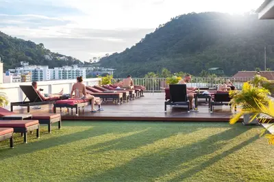 a group of people sitting on a deck on a roof at Paripas Patong Resort in Patong Beach