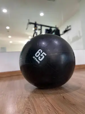 a black ball sitting on a wooden floor with a bike at Paripas Patong Resort in Patong Beach