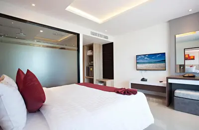 a bedroom with a large white bed with red pillows at Paripas Patong Resort in Patong Beach