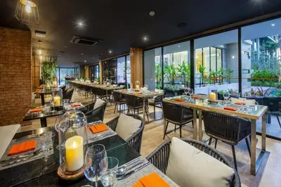 a restaurant with tables and chairs and large windows at Apartment Diamond Resort BangTao in Bang Tao Beach