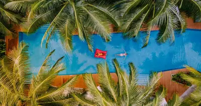 a blue wall with palm trees and a red flag at Apartment Diamond Resort BangTao in Bang Tao Beach