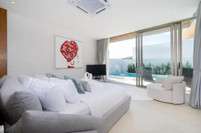 a living room with a white couch and a large window at The Trinity new modern 5BR villa with 20M Pool in Thalang