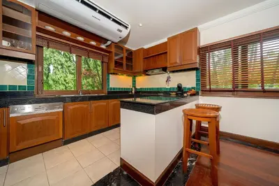 a kitchen with wooden cabinets and a counter top at Laguna Lakeshore Villas Residence - Spacious Townhouse with Tropical Pool Access in Bang Tao Beach
