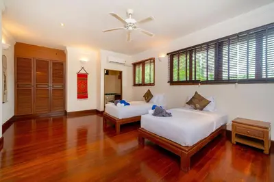 a bedroom with two beds and a ceiling fan at Laguna Lakeshore Villas Residence - Spacious Townhouse with Tropical Pool Access in Bang Tao Beach
