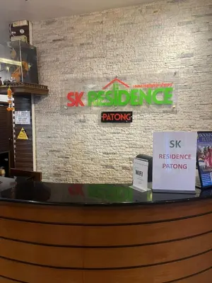 a restaurant counter with signs on a brick wall at SK Residence And Restaurant Patong in Patong Beach