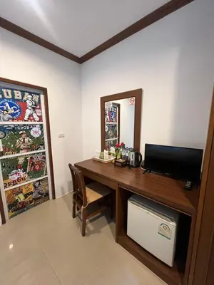 a room with a desk with a television and a mirror at SK Residence And Restaurant Patong in Patong Beach