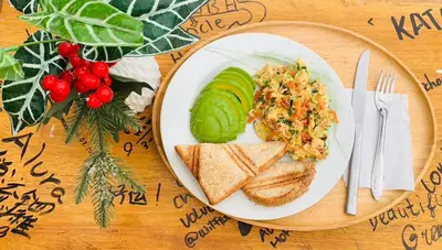 a plate of food with bread and vegetables and a sandwich at Alura Guesthouse in Kata Beach